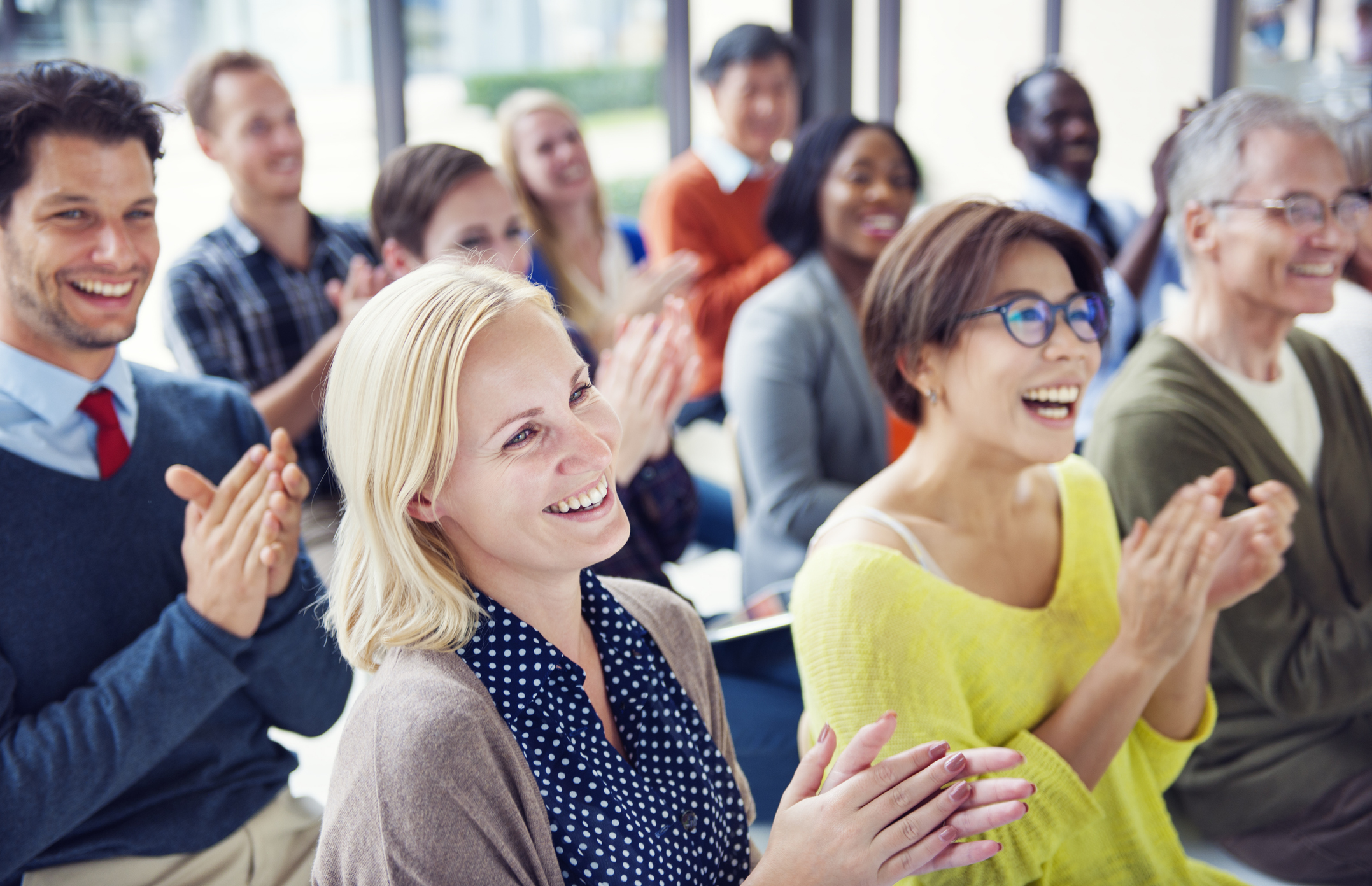 Happy training attendees in a live mental health education setting